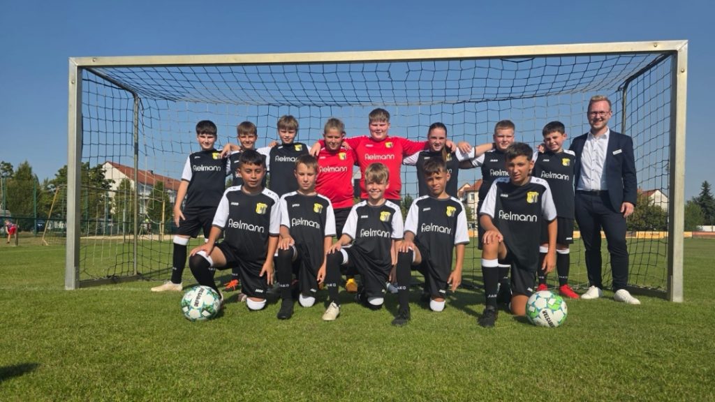 D2-Jugend des SV Concordia Schenkenberg im neuen schwarzen Trikotsatz von Fielmann, Gruppenfoto vor dem Tor mit Sponsor