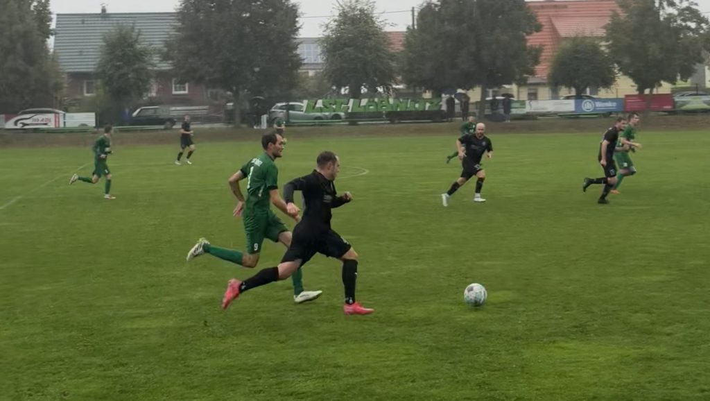 Spieler des SV Concordia Schenkenberg im Auswärtsspiel bei der LSG Löbnitz im Laufduell auf nassem Rasen.