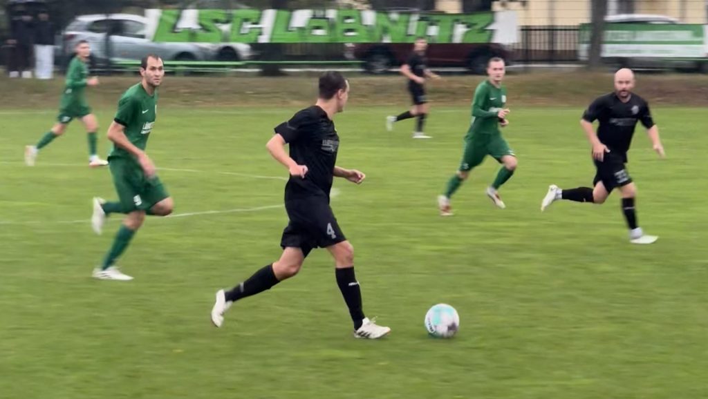 Spieler des SV Concordia Schenkenberg führt den Ball beim Auswärtsspiel in Löbnitz über den tiefen Rasen.