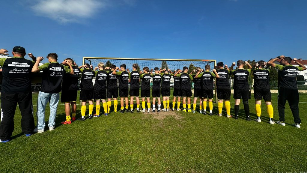 A-Jugend des SV Concordia Schenkenberg zeigt geschlossen die Rückseite der neuen Polo-Shirts mit dem Logo von Till & Partner Immobilien.