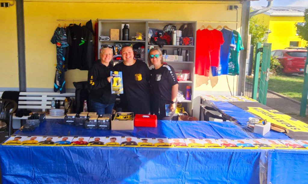 Drei Helferinnen posieren am Merchandise-Stand beim Vereinsfest SV Concordia Schenkenberg